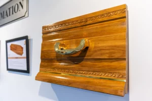 Échantillon de cercueil en bois sculpté avec poignée dorée.