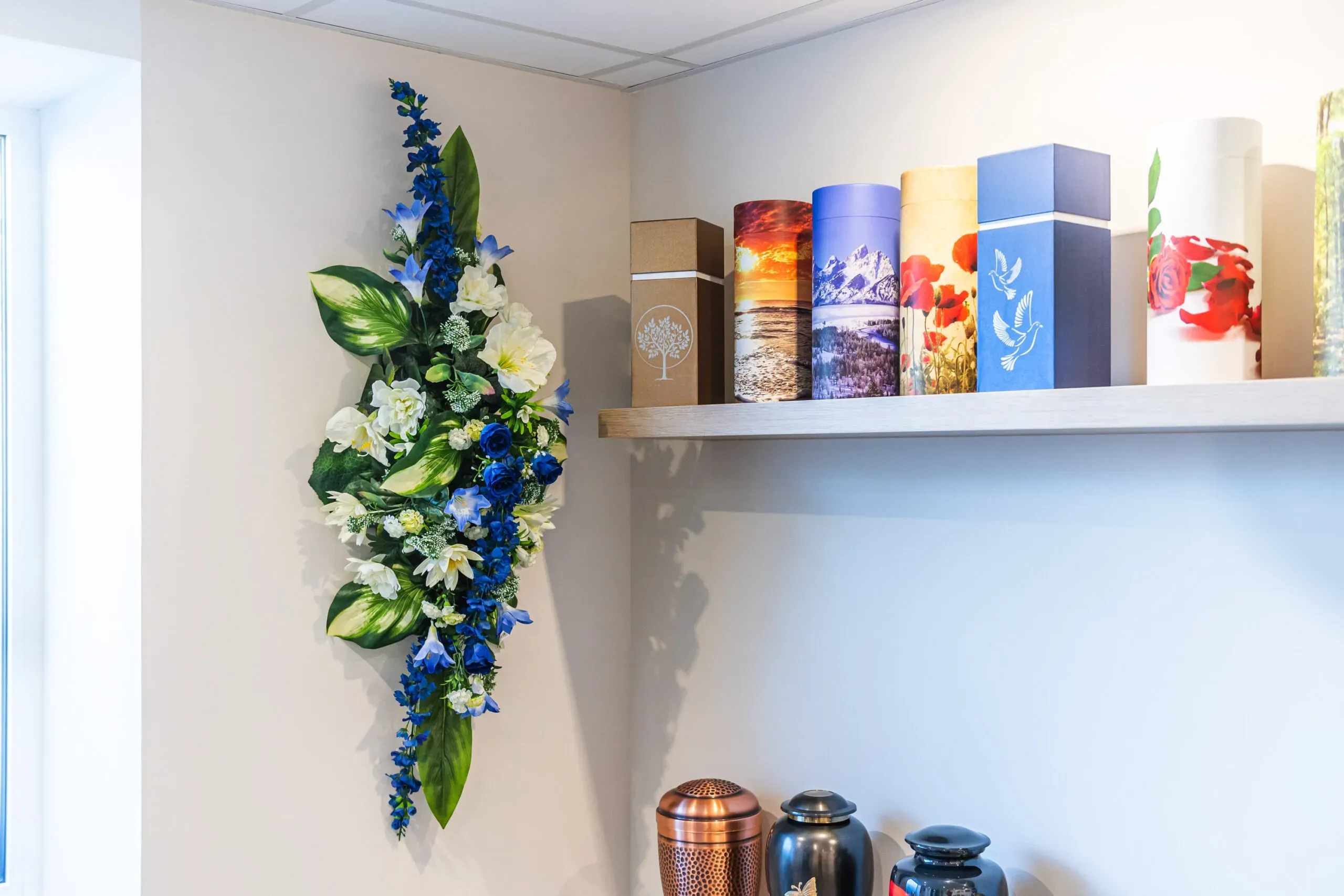 Urnes funéraires illustrées et composition florale bleues et blanches.