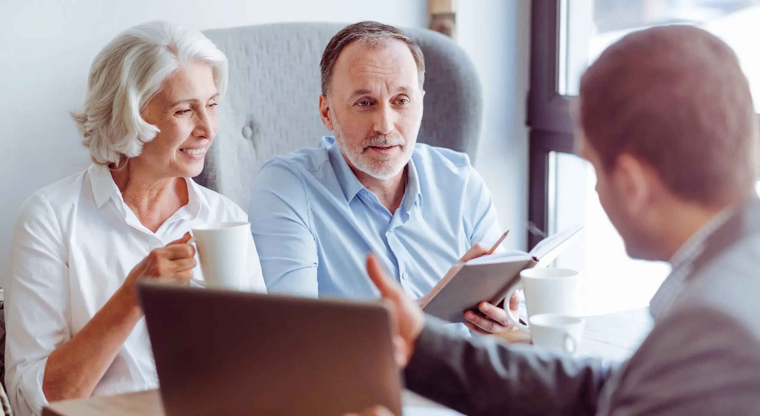 Conseiller funéraire en rendez-vous avec un couple senior.
